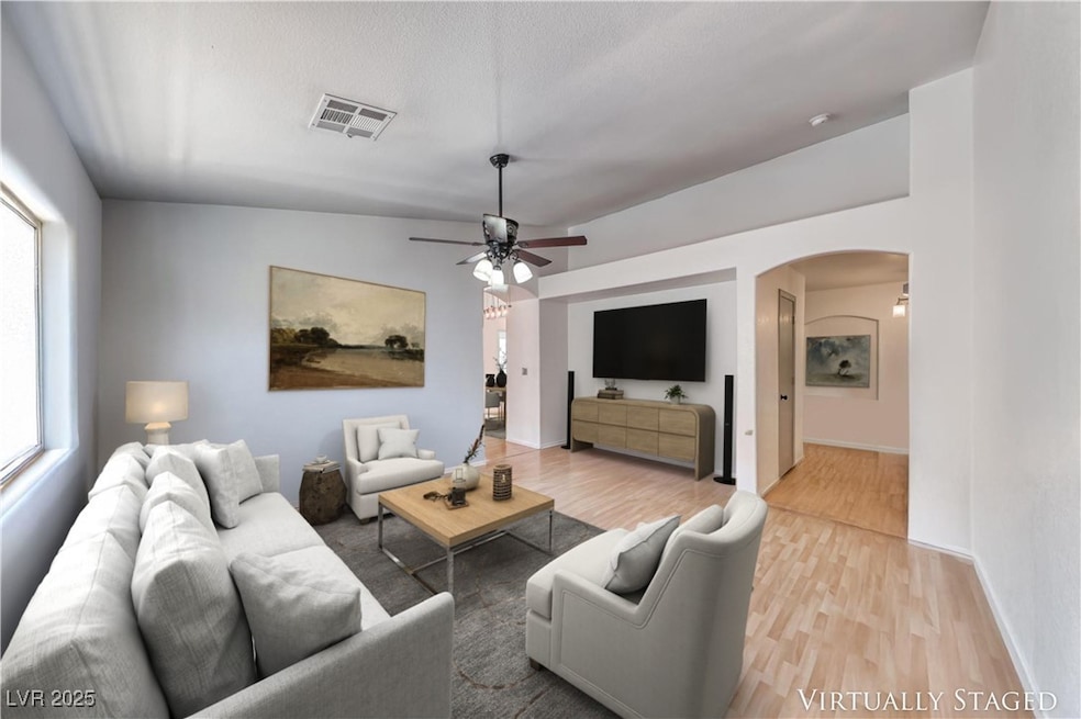 Living area featuring arched walkways, light wood