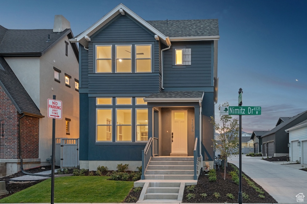 View of front facade with concrete driveway, roof with shingles, a gate, and a yard