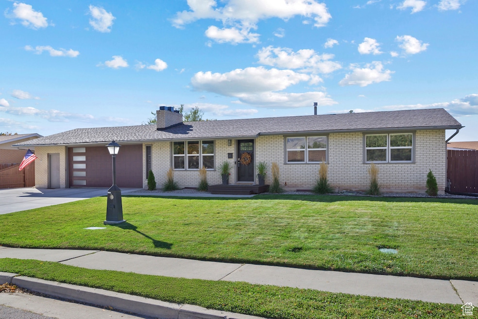 Ranch-style house with concrete driveway, a chimney, brick siding, a garage, and a shingled roof