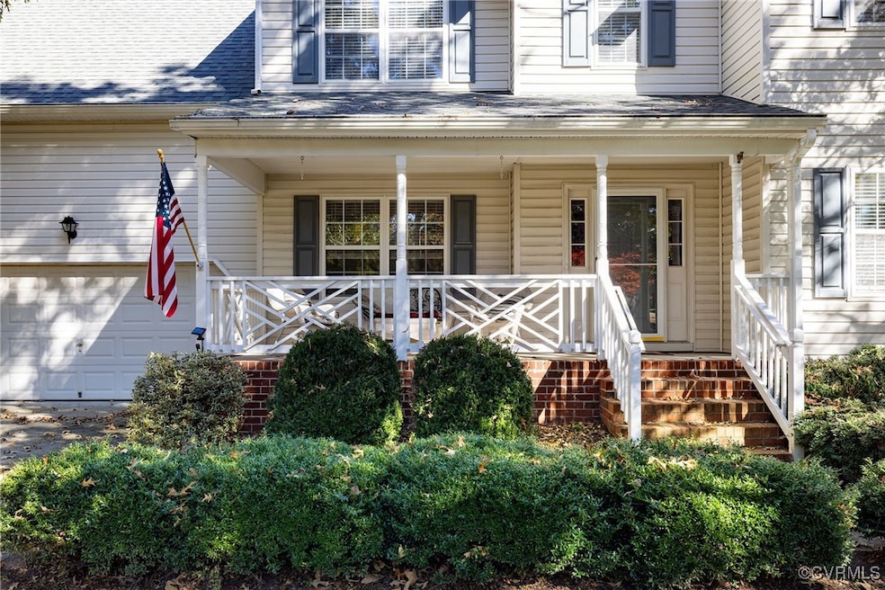 View of exterior entry with covered porch and a ga