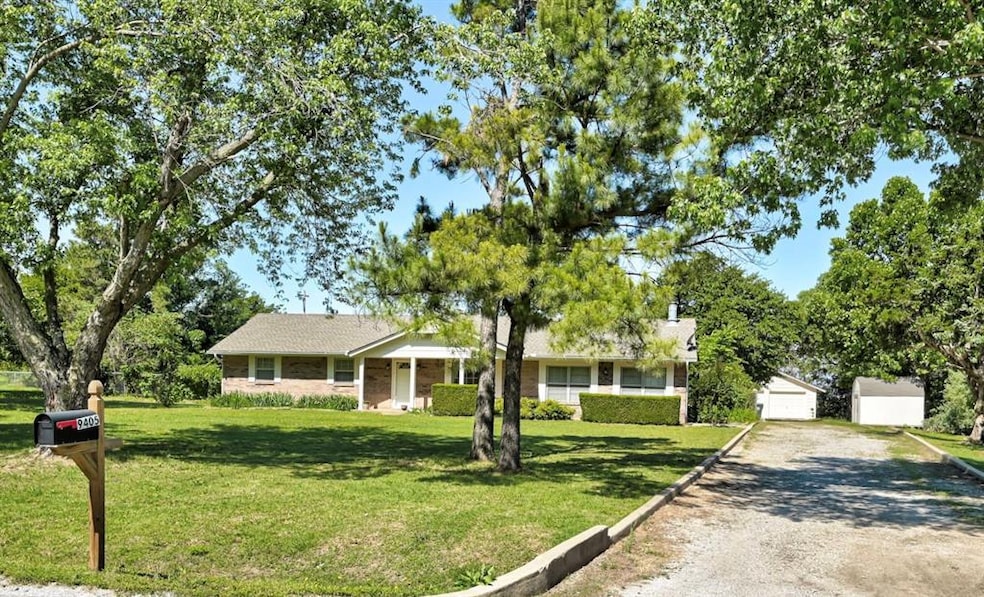 Ranch-style house featuring a front lawn, an outdoor structure, driveway, and brick siding