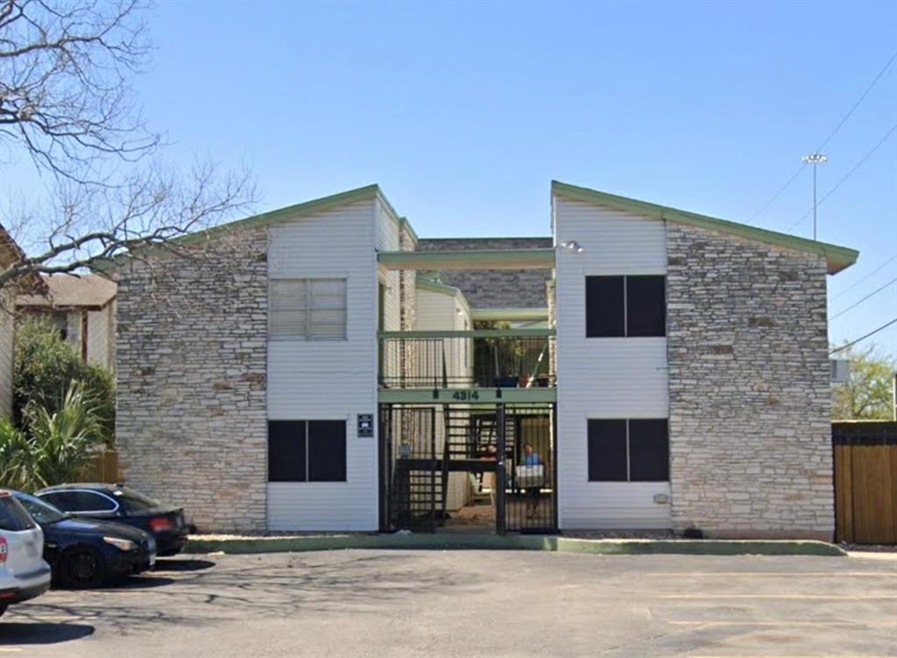 View of building exterior with uncovered parking