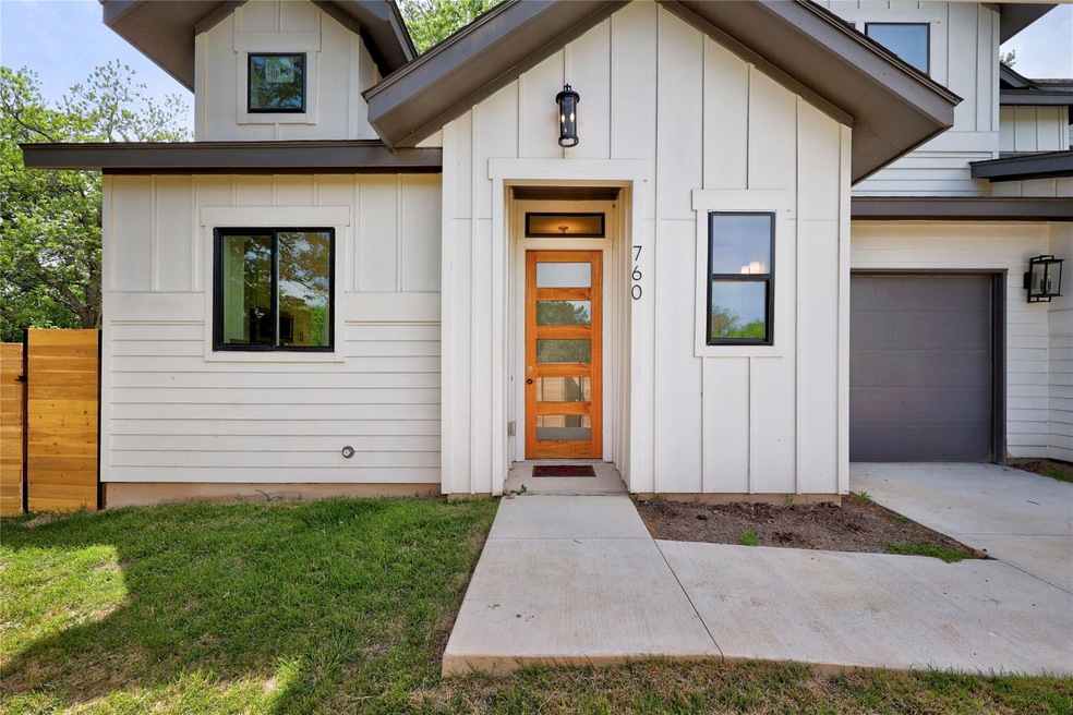 Property entrance with fence, concrete driveway, 