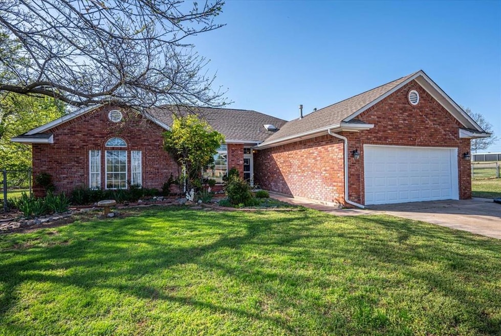 Single story home featuring concrete driveway, roo
