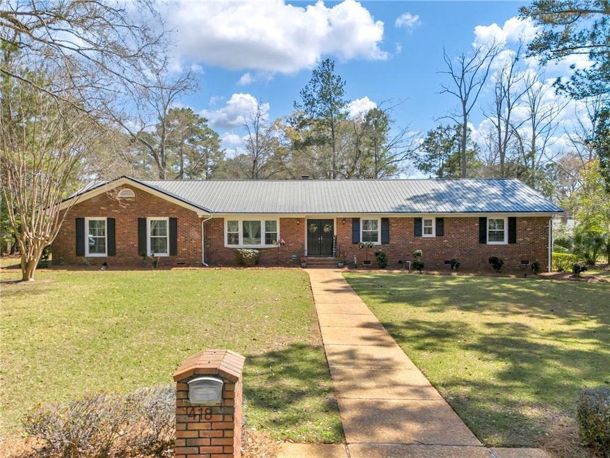 Ranch-style home featuring brick siding, metal roo
