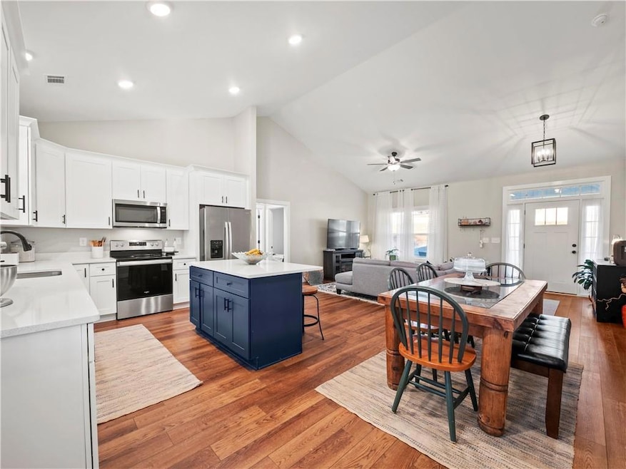 Kitchen with pendant lighting, blue cabinetry, whi