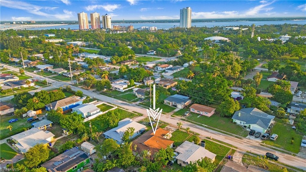 Aerial view of property's location featuring a nearby body of water and nearby suburban area