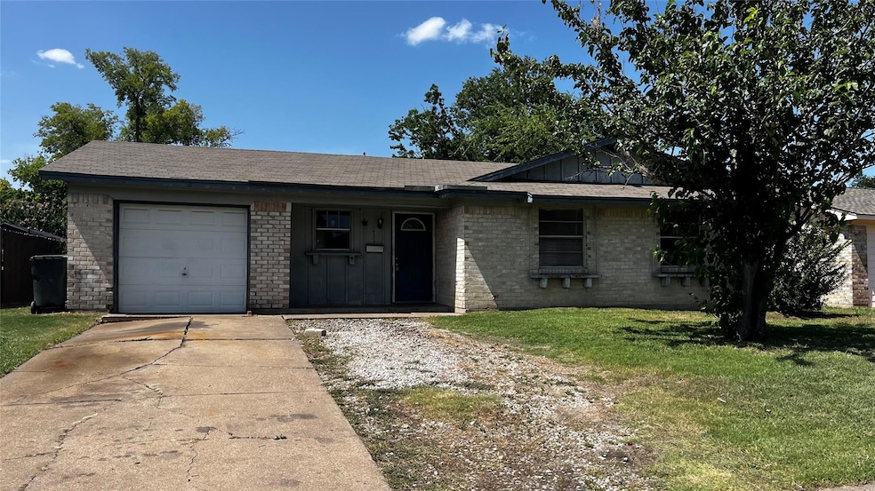 Ranch-style house with a garage and a front lawn