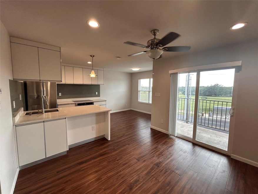 Kitchen with light countertops, dark wood-style f