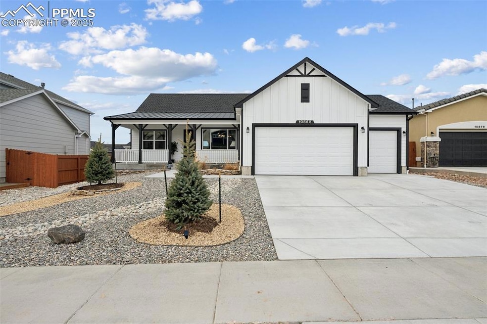 View of front of house featuring board and batten siding, covered porch, an attached garage, and concrete driveway