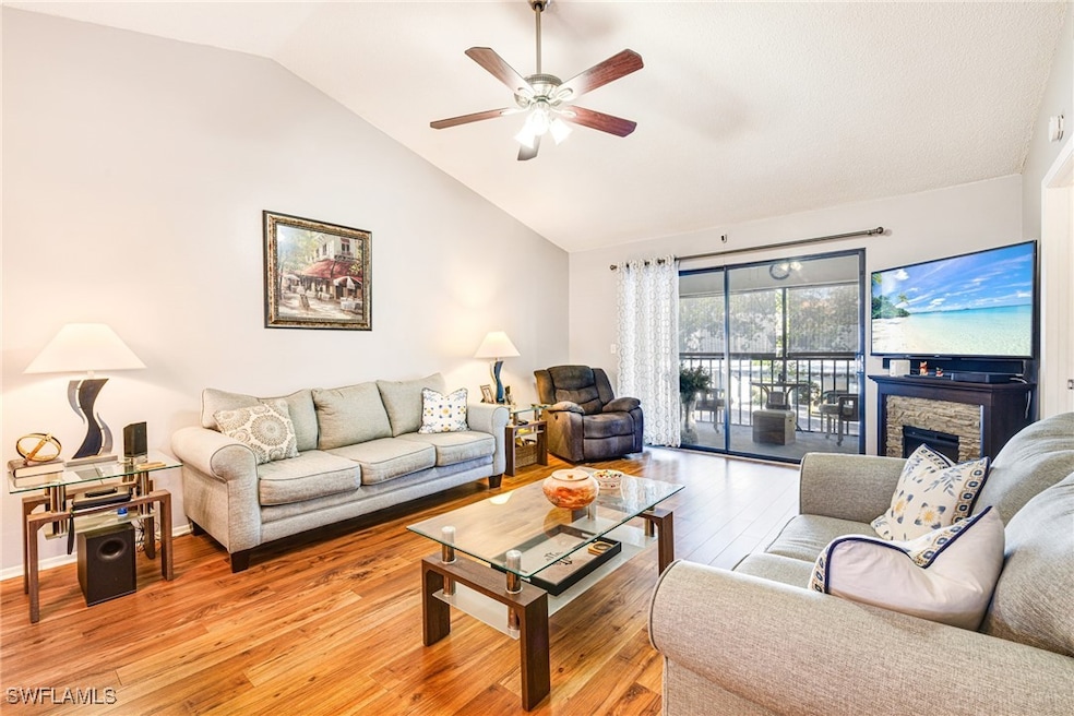 Living room featuring lofted ceiling, a ceiling fa