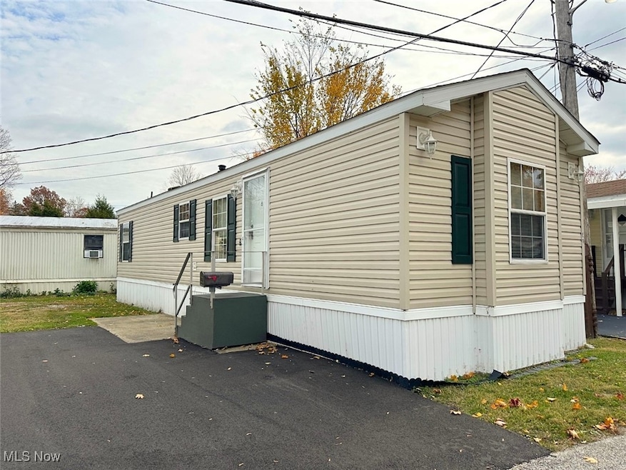View of property exterior featuring a lawn
