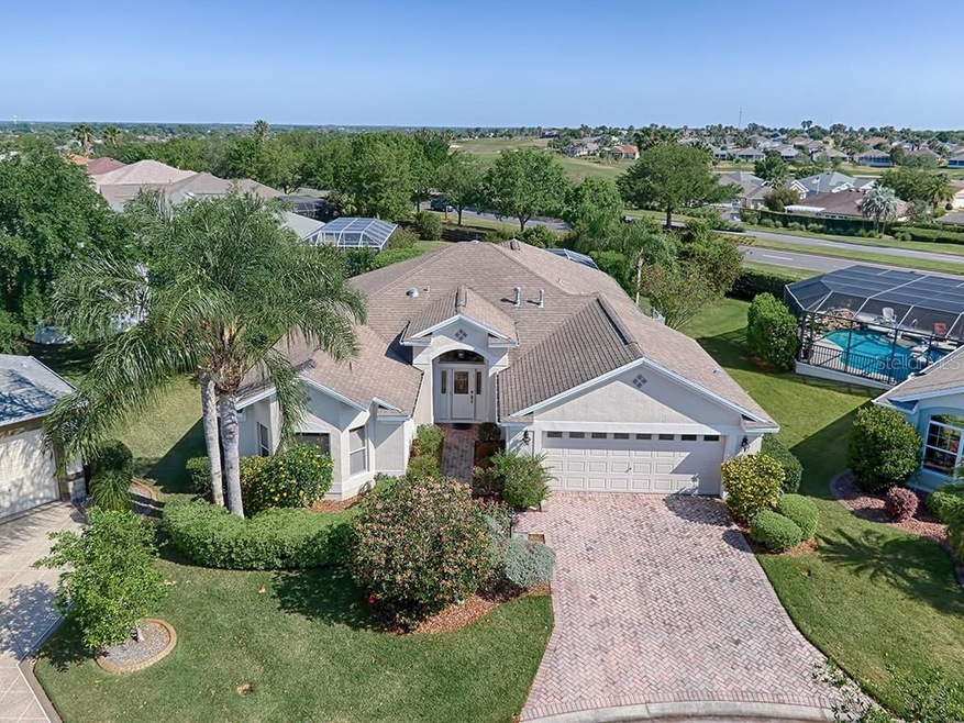 A paver drive and lush landscaping create lovely c