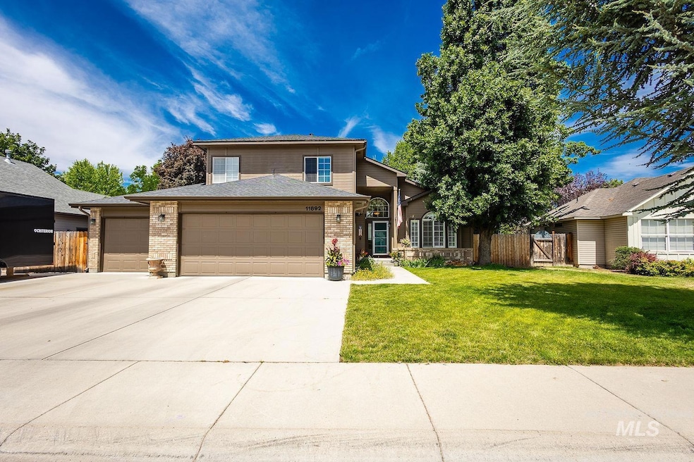 View of front of house with a garage, brick siding, and driveway