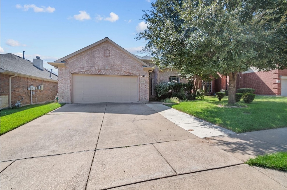 View of front of property featuring brick siding, a front yard, concrete driveway, and a garage
