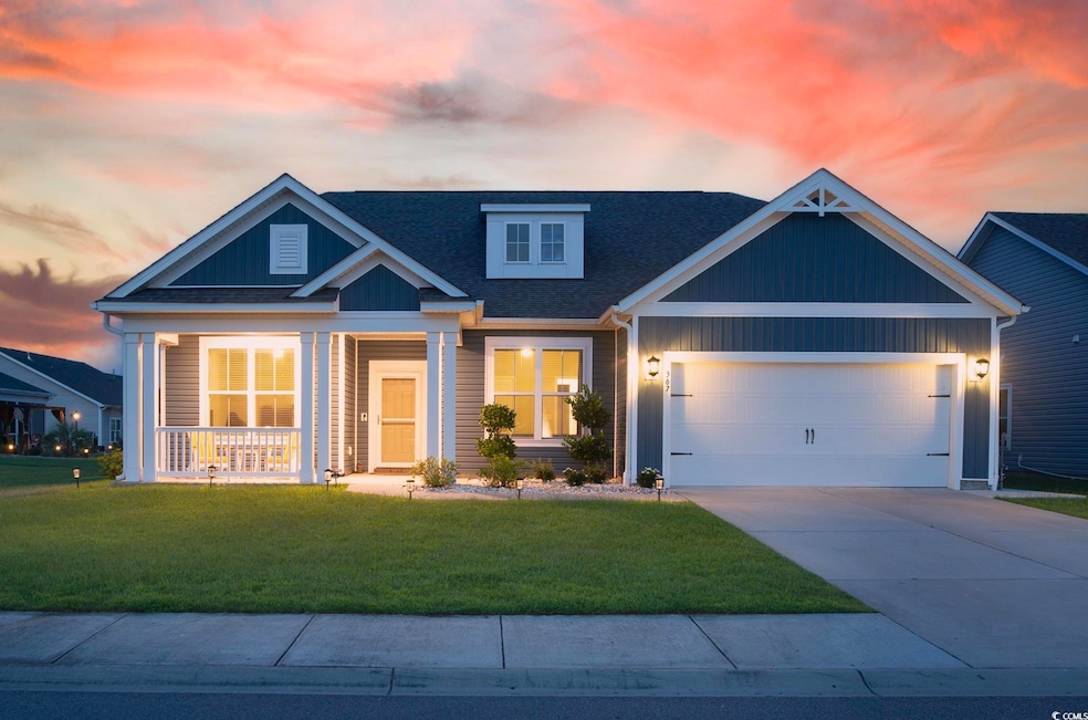 View of front of house featuring a front yard, concrete driveway, a shingled roof, a porch, and an attached garage