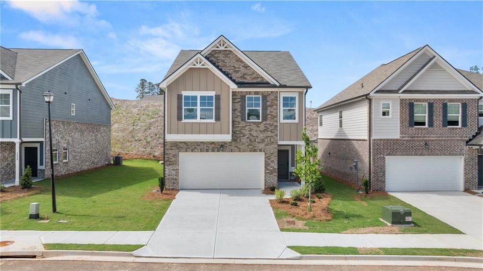Craftsman-style house featuring board and batten siding, an attached garage, driveway, and a front yard
