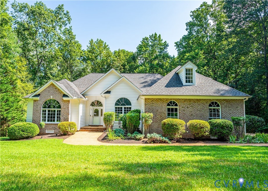 View of front of home with roof with shingles, brick siding, and a front yard