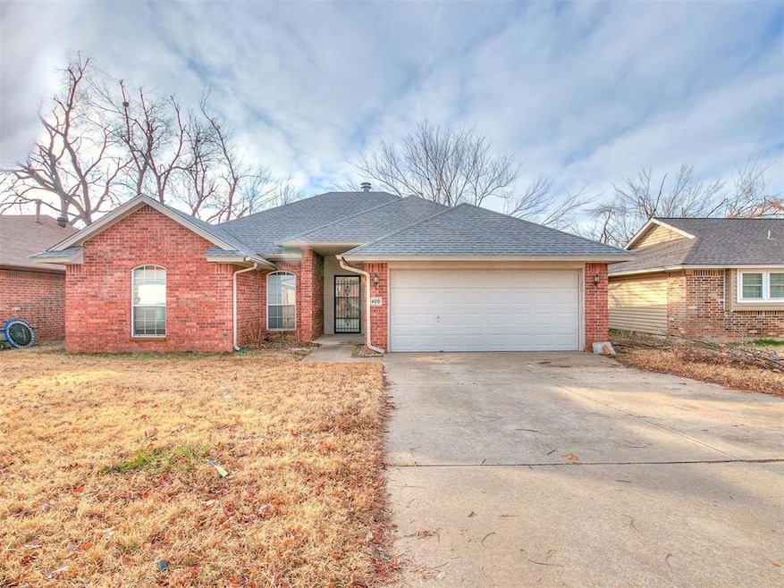 Ranch-style house with an attached garage, driveway, roof with shingles, and brick siding