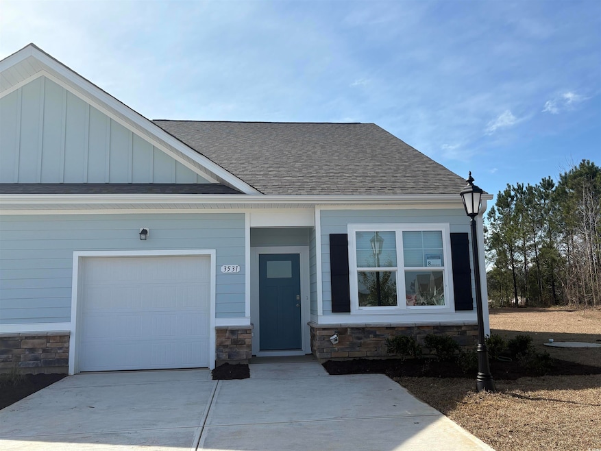 View of front of house featuring a garage, a shing