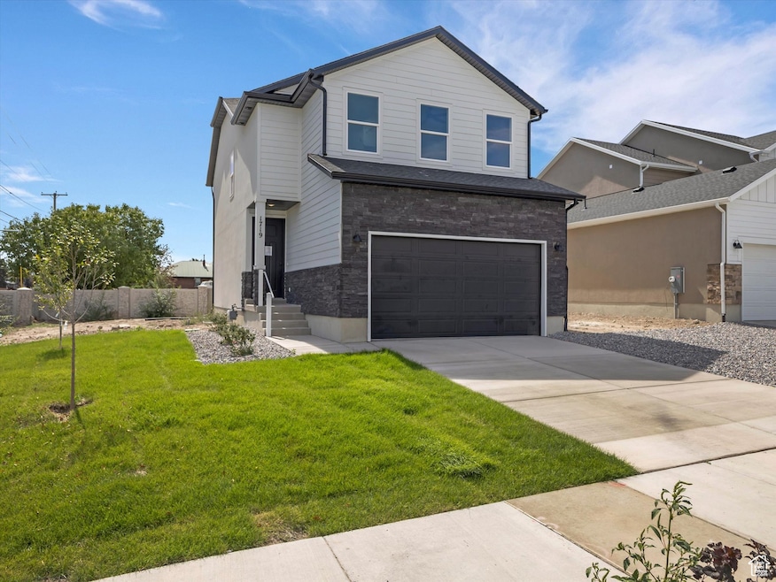 View of front of home with concrete driveway, a garage, and brick siding