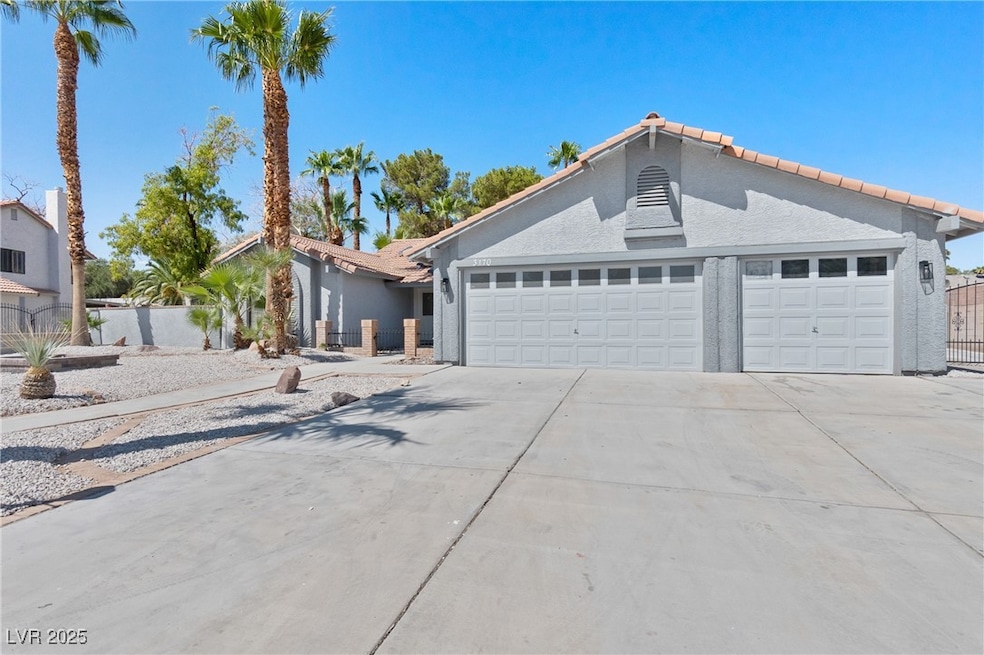 View of front of house featuring a garage, driveway, stucco siding, and a tile roof