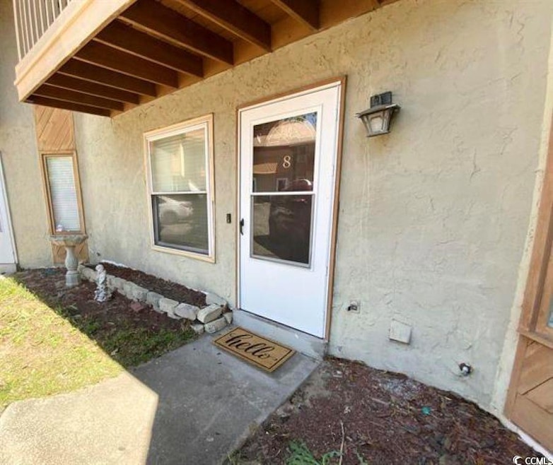 Doorway to property featuring stucco siding