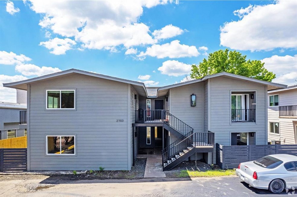View of front of house featuring fence and stairs