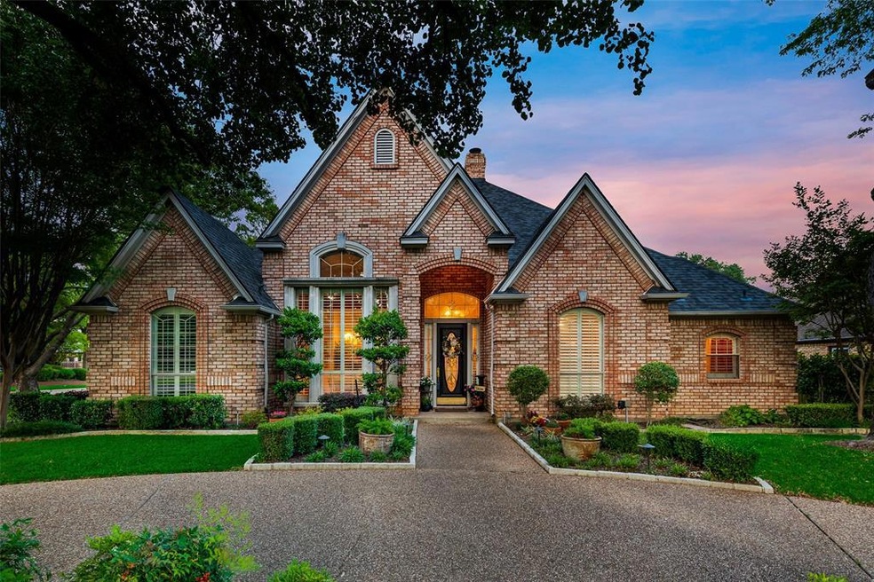 A circle driveway and large shade trees welcome yo