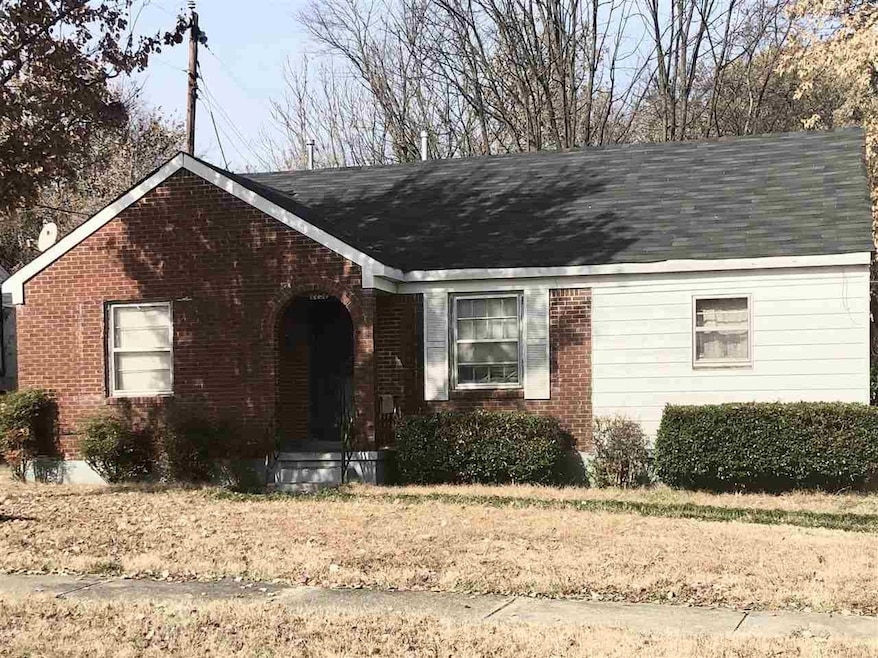 View of front of house featuring brick siding and roof with shingles