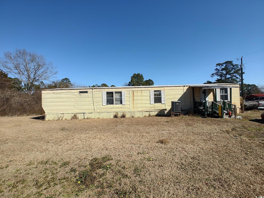 Rear view of property with a yard and central air 
