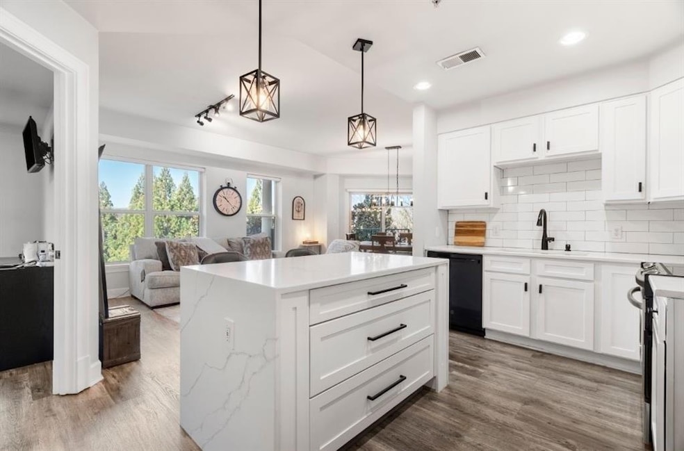 Kitchen featuring visible vents, a sink, dishwashe