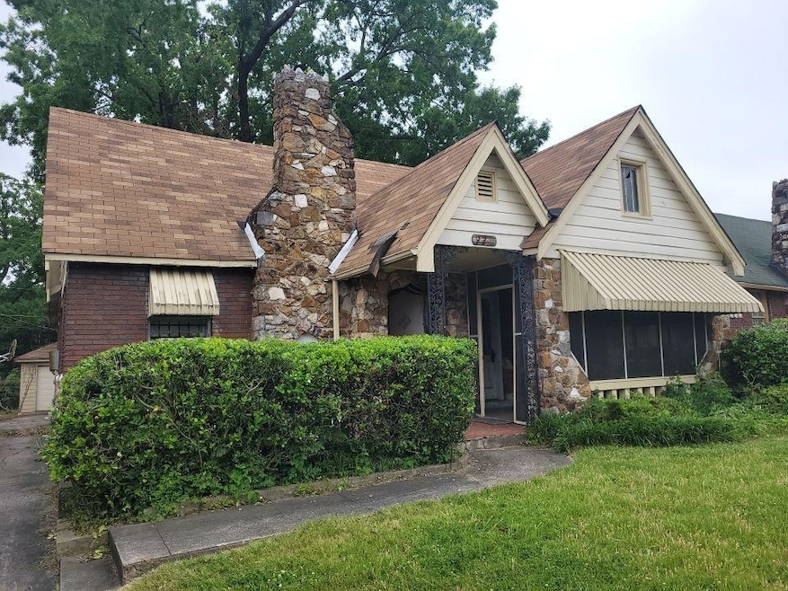 View of front of home with stone siding, a chimney