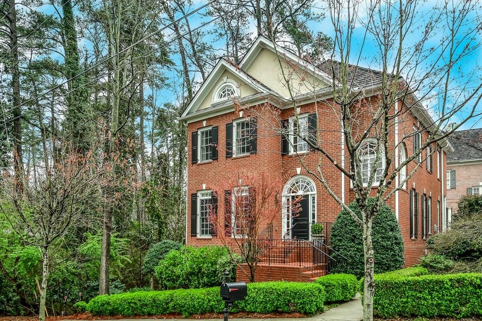 Beautiful brick home with wooded view to the left.