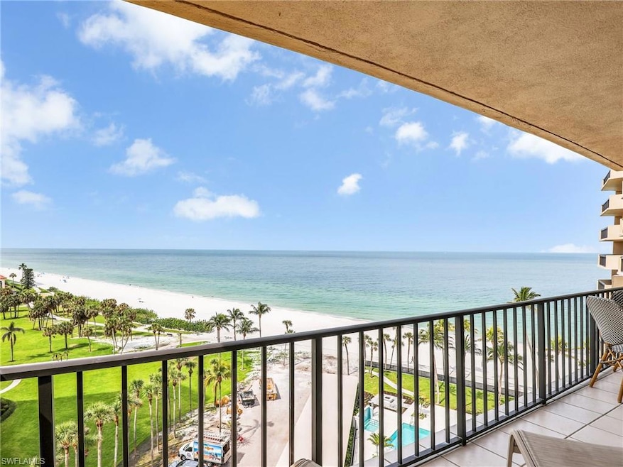 Balcony featuring view of water and beach