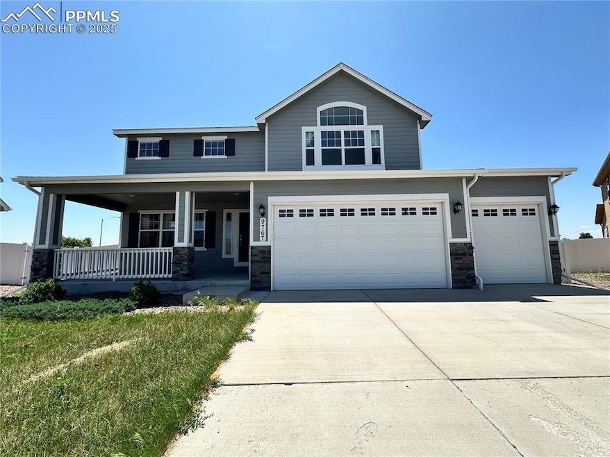 View of front of home with covered porch, driveway, stone siding, and a garage