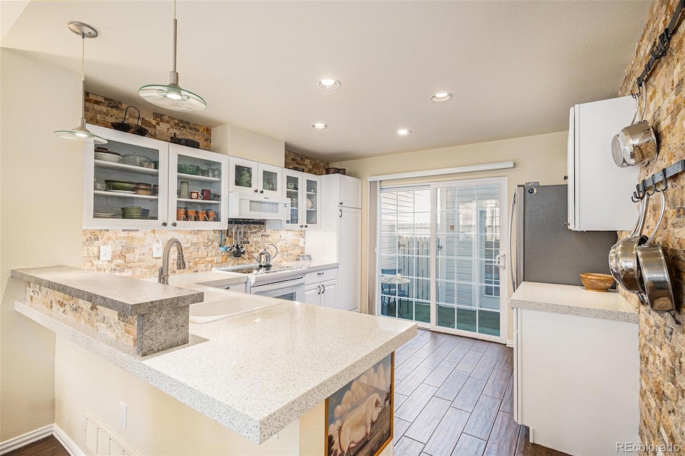 Kitchen with upgraded stone backsplash throughout. The sliding door leads to the patio and bonus room.