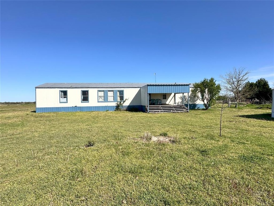 Front view of house featuring a yard and an outdoo