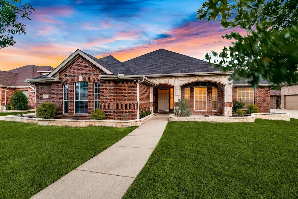 View of front of home with a garage and a lawn