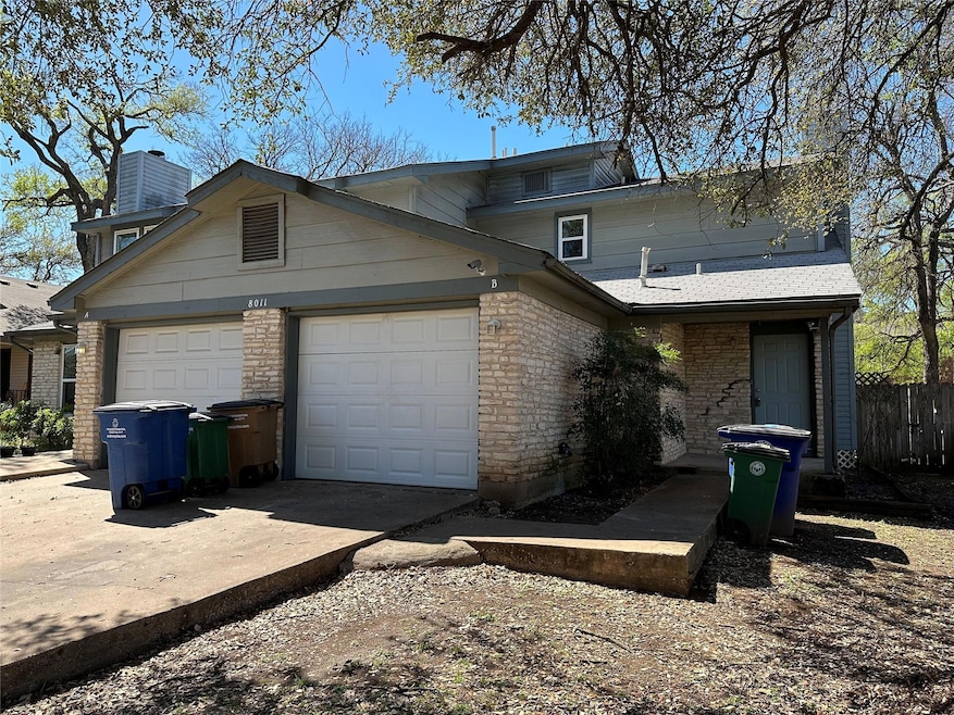 Traditional home with a chimney, concrete driveway, a garage, brick siding, and a shingled roof