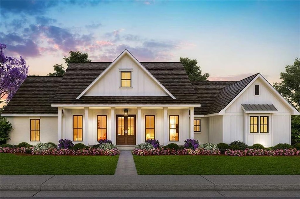 View of front of home with board and batten siding, covered porch, and a lawn
