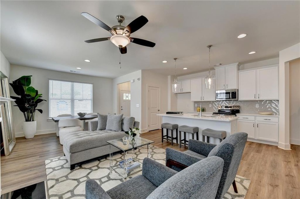Living room featuring ceiling fan, light wood-type