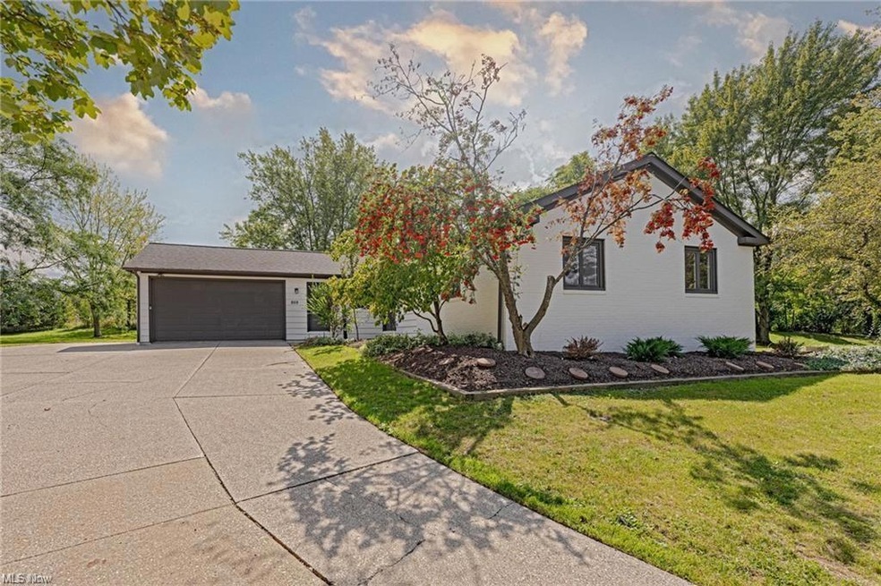 Ranch-style home featuring a garage and a front ya