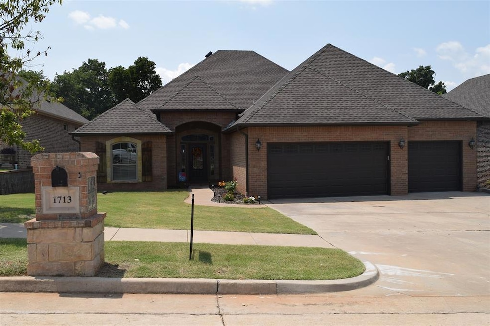 French country inspired facade featuring a garage, brick siding, a shingled roof, and concrete driveway