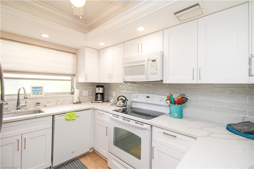 Kitchen featuring white appliances, decorative bac