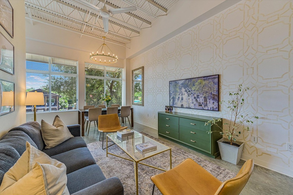 Living room featuring baseboards, a chandelier, w