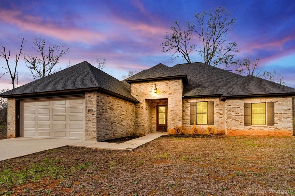 View of front of house featuring a yard and a gara