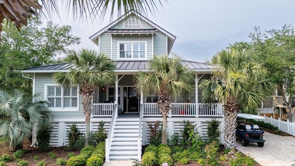 Beach home with covered porch, stairs, a standing seam roof, and metal roof