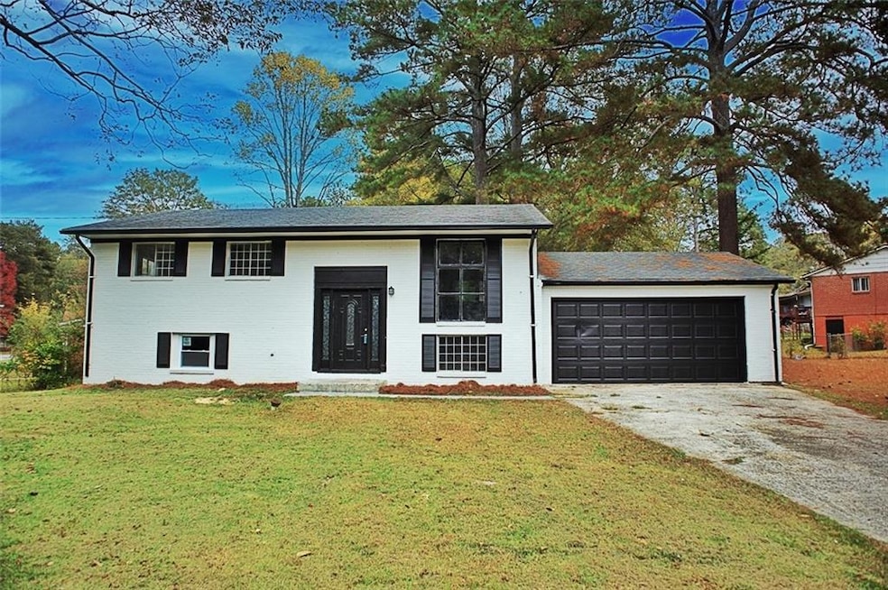 Bi-level home featuring a garage and a front lawn
