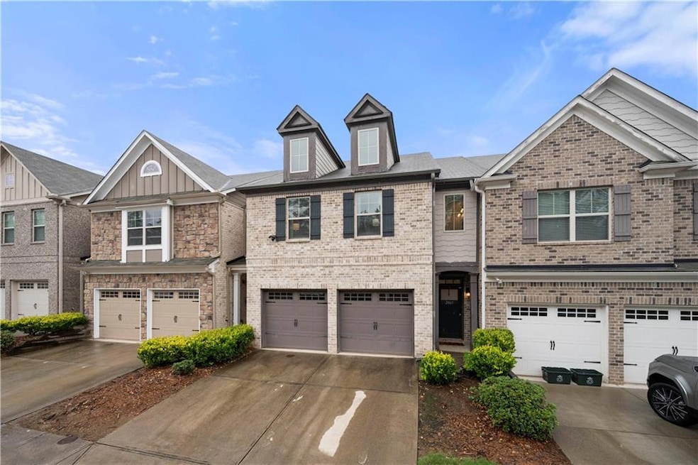 View of front of house with a garage, brick siding, and driveway
